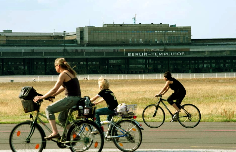 People cycling on runway at new city public Tempelhofer Park on site of famous former Tempelhof Airport in Berlin Germany