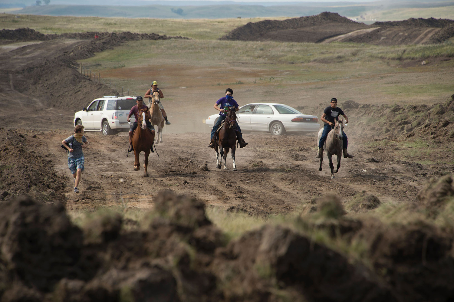 Protestors on horseback gallop away after members of the Standing Rock Sioux tribe and their supporters confronted a bulldozer crew and the private security team protecting the work site for the Dakota Access Pipeline (DAPL), near the Standing Rock Indian Reservation near Cannon Ball, North Dakota, September 3, 2016.    The protestors, who call themselves water protectors, left the area after forcing the pipeline workers and security crew to retreat.  / AFP / Robyn BECK        (Photo credit should read ROBYN BECK/AFP/Getty Images)